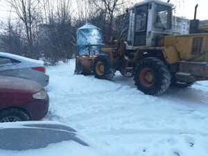 Уборка снега автогрейдером во дворе дома по улице Красноармейская 160-а